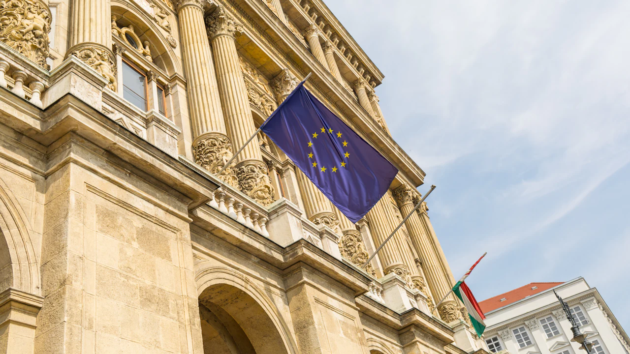 Historisches Verwaltungsgebäude mit Säulenfassade, an dem die Flagge der Europäischen Union hängt